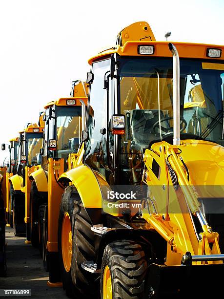 Diggers In A Row On Industrial Parking Lot Stock Photo - Download Image Now - Construction Equipment, New, Backhoe