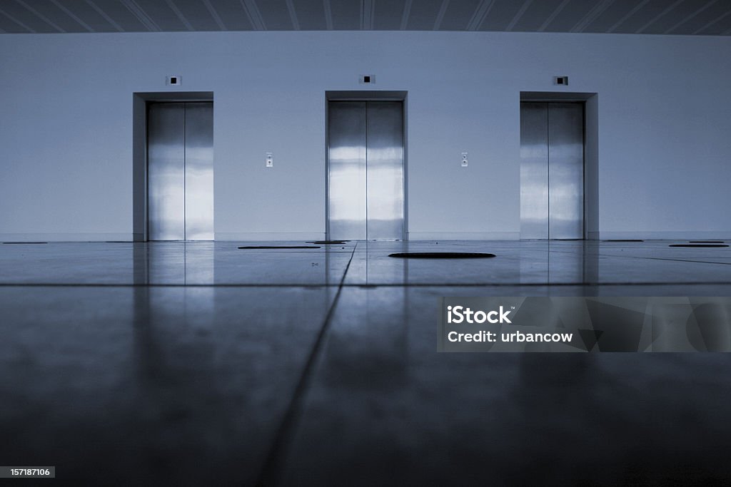 Elevators A row of three lifts, blue tint Three Objects Stock Photo