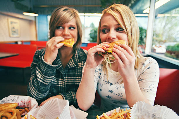 istock Burger Consuming Caucasian Females 157187161