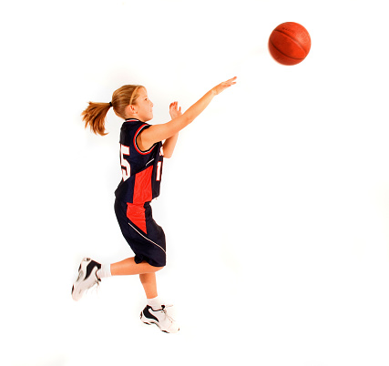 a 12 year-old girl, in basketball uniform, shooting a basket