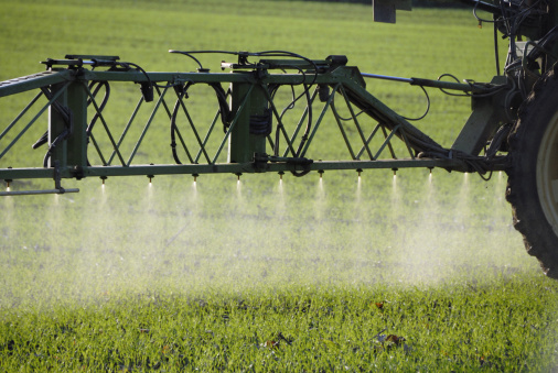 detail of tractor sprayer, spraying fertilizer on a field