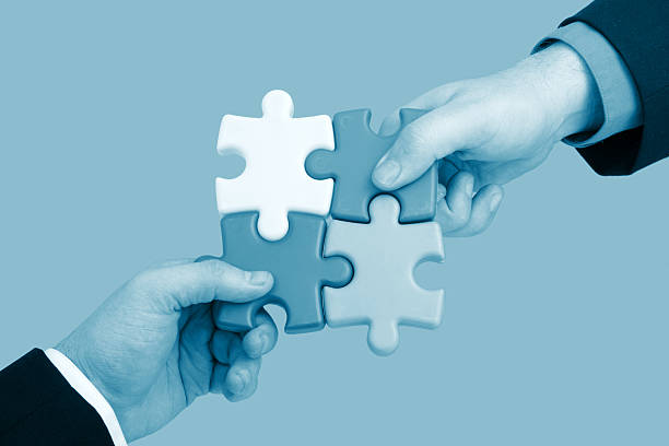 istock Partnership concept showing two men putting together puzzle 157187346