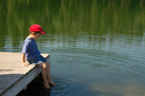 8 year old child fishing in the lake on a sunny morning in Brazil.