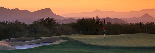 vue panoramique du parcours de golf desert golf course sous hazy orange ciel. - catus photos et images de collection