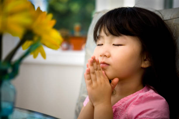 istock Little girl praying 157187545