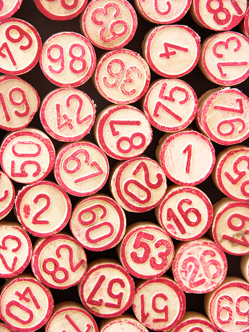 Pieces of cheap bingo game showing numbers. Top view, full frame