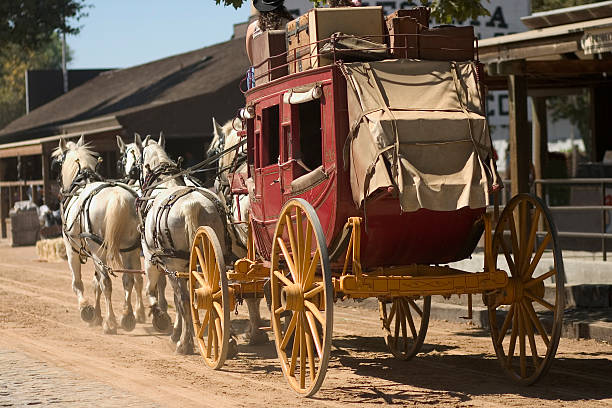 Old western stagecoach from the 1800s Antique stagecoach travelling down an old western street. horse cart photos stock pictures, royalty-free photos & images