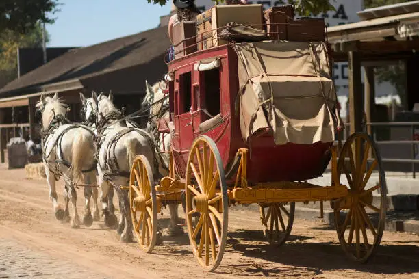 Antique stagecoach travelling down an old western street.