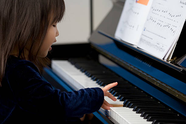 Cute girl playing a Piano stock photo