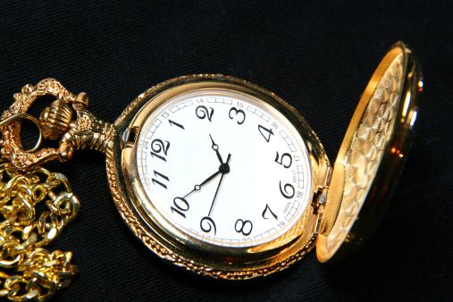 Silver pocket watch on a wooden table. Pocket watches on a silver chain. Closed pocket watch.