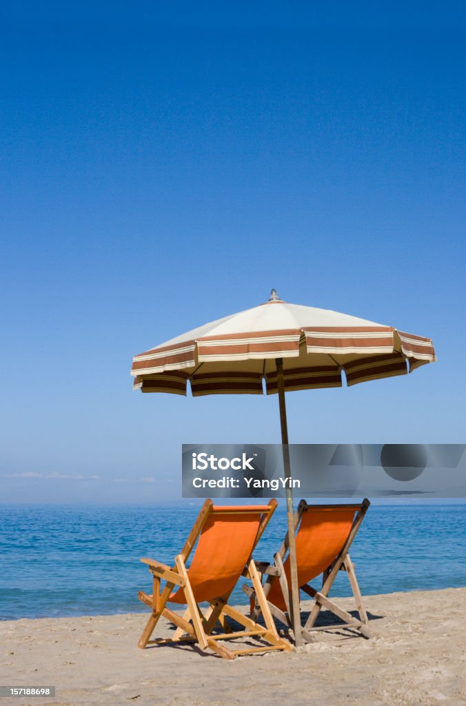 Dos sillas y sombrilla en la playa de mar para Vacaciones tropicales - Foto de stock de Azul libre de derechos