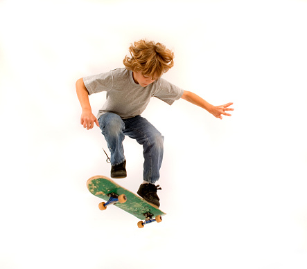 a 12- year old boy poses with his skateboard