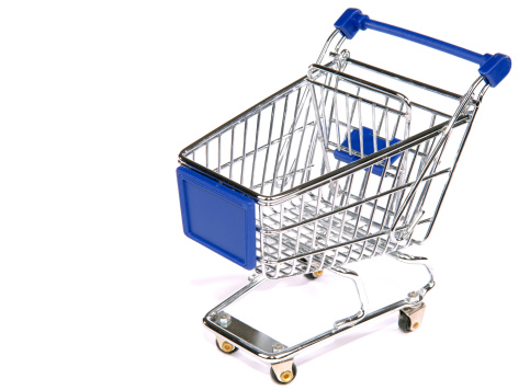 Shopping cart full of groceries on white background, above view