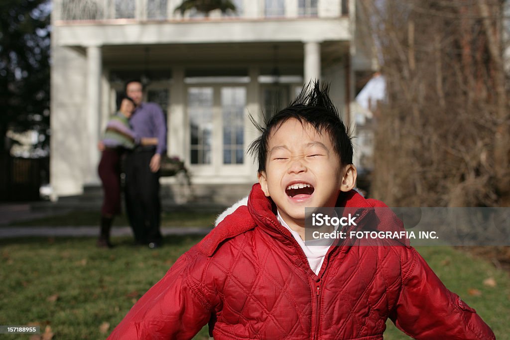 Outside Young Asian Family in the back yard of their new Home. Daughter in the foreground smiling, Adult Stock Photo