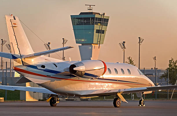 Business jet parked in front of the control tower stock photo