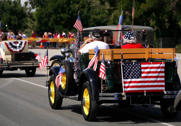 Antique car in July 4th parade This patriotic retired couple drove their beautifully preserved antique car in a local Fourth of July parade. parade stock pictures, royalty-free photos & images
