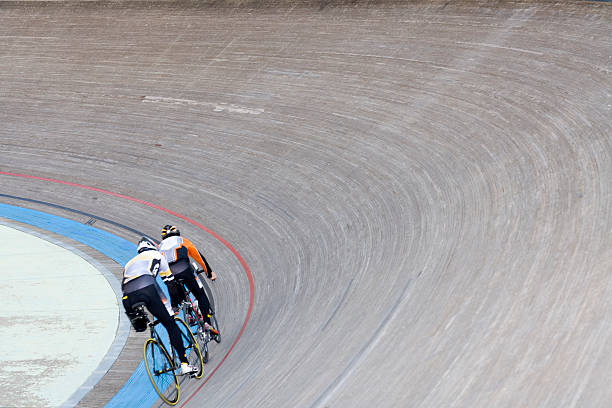 Bicycle velodrom training bicycle racers flying around a turn in a racing velodrome, slight motion blur velodrome stock pictures, royalty-free photos & images