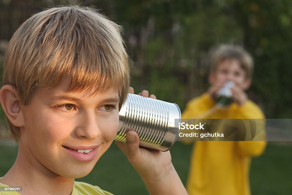 Tin Can Telephone Children playing with a tin can telephone. Child Stock Photo