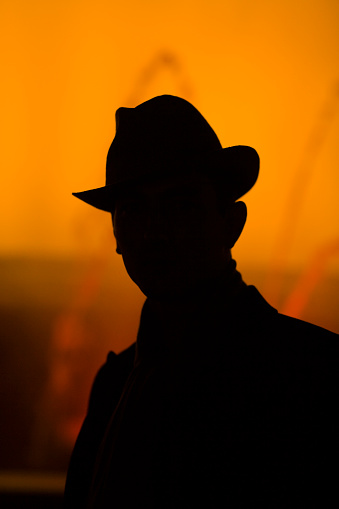 detective silhouette in front of colorful fountain, night shot. agent, police, secret concept