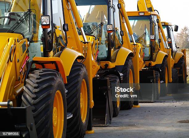 Diggers In A Row On Industrial Parking Lot Stock Photo - Download Image Now - Construction Equipment, Construction Machinery, Machinery