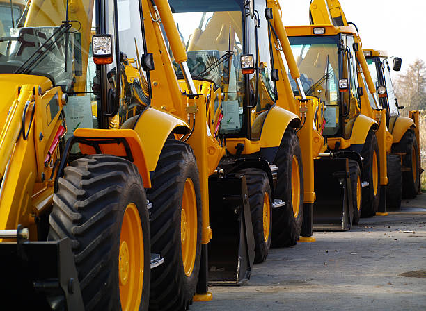 diggers w rzędzie na parkingu przemysłowe - earth mover construction industrial equipment bulldozer zdjęcia i obrazy z banku zdjęć