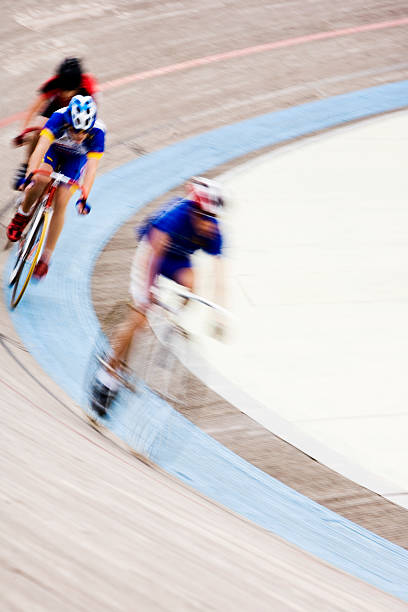 speed The leading bicycles race round the track. Motion blur on both the cyclists and the track. velodrome stock pictures, royalty-free photos & images