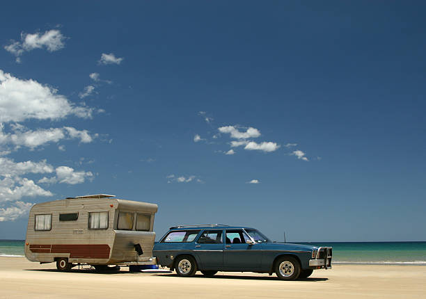 Old caravan & car on beach stock photo