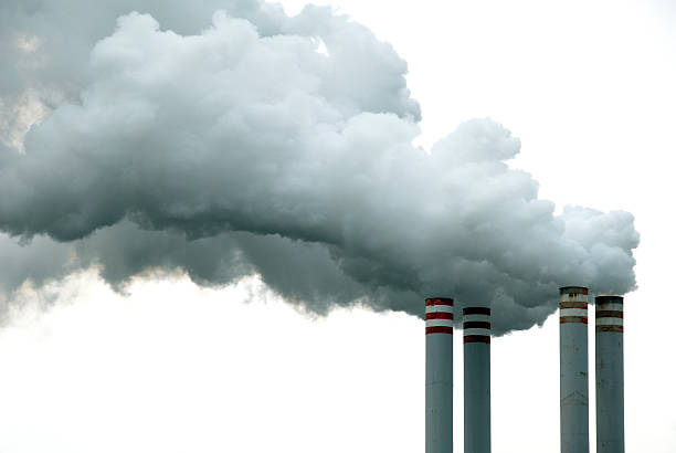 Four Chimneys and Smoke Four chimneys releasing a fantastic amount of smoke. Ideal image to highlight climate change, global warming and greenhouse issues. smoke stack photos stock pictures, royalty-free photos & images