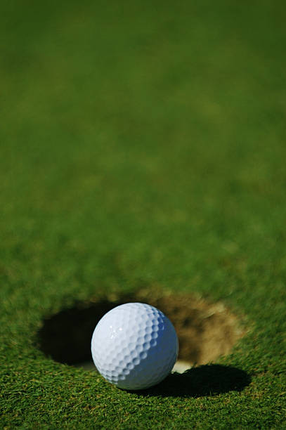 White Golf ball on a beautiful golf course next to a note