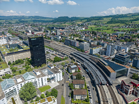 Aerial view of Swiss City of Zug with railway station and black skyscraper on a sunny spring day. Photo taken May 22nd, 2023, Zug, Switzerland.