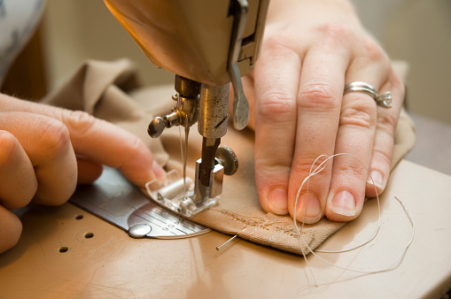 Hands work a sewing machine
