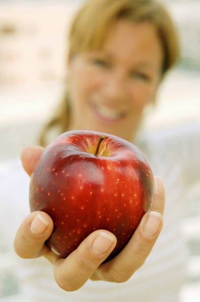 istock Woman offering an apple 157190288