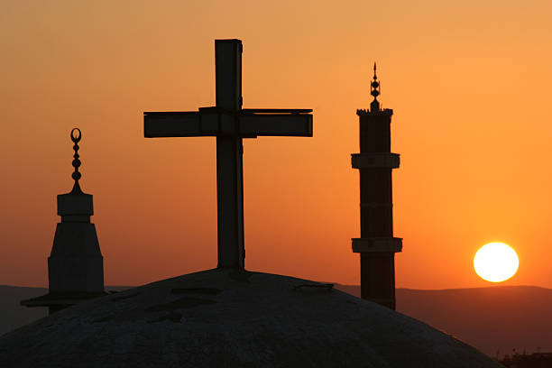 Egyptian sunrise with cross and crescents Sunrise over village in central Egypt - looking over a church's dome to mosque minarets mosque photos stock pictures, royalty-free photos & images