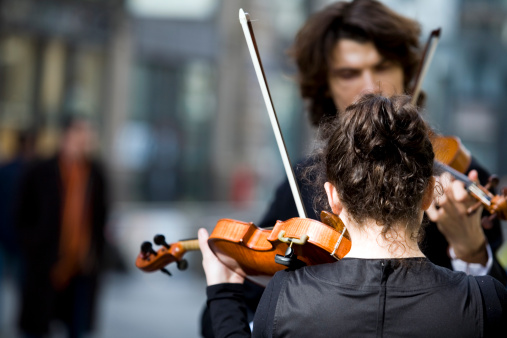Two violinists play for passers-by in Vienna, Austria.