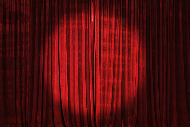 Spotlight on the Stage Curtain Bright spotlight on the stage curtain. red velvet material stock pictures, royalty-free photos & images