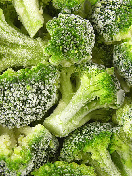 Frozen broccoli background Closeup view of frozen broccoli frozen food stock pictures, royalty-free photos & images
