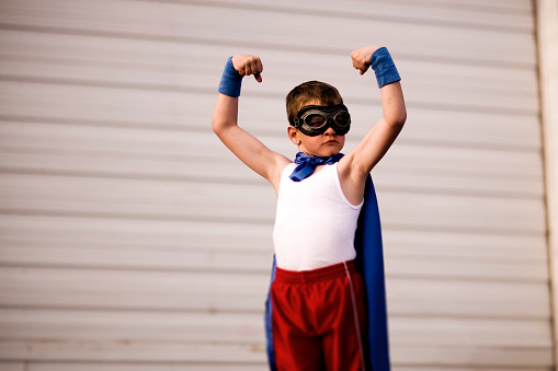 A young superhero flexes his muscles and is ready for the next challenge. Tilt shift focus. Don't mess.