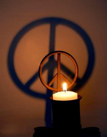 Peace symbol candle casts a shadow.