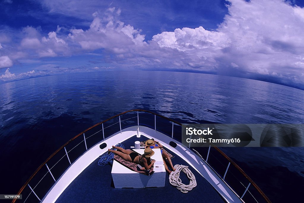 Meninas tomando banho de sol no barco - Foto de stock de Cruzeiro royalty-free