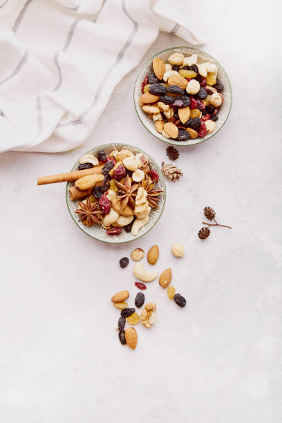 istock Aesthetic saucers with different nuts top view. Walnuts, almonds, hazelnuts and cashews. Raisins and cranberries on white background. Healthy desserts and snacks. concept 1571913731