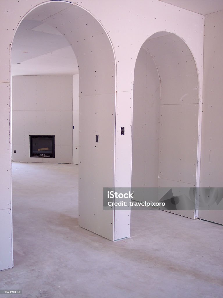 Drywall Arches Walkway arches seen in an unfinished home construction. Fireplace in the background. Arch - Architectural Feature Stock Photo