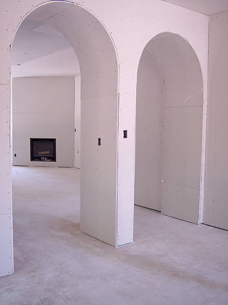 Drywall Arches Walkway arches seen in an unfinished home construction. Fireplace in the background. drywall fireplace stock pictures, royalty-free photos & images