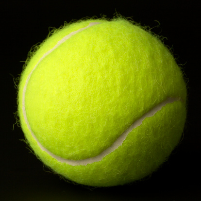 New tennis ball. Isolated on black.