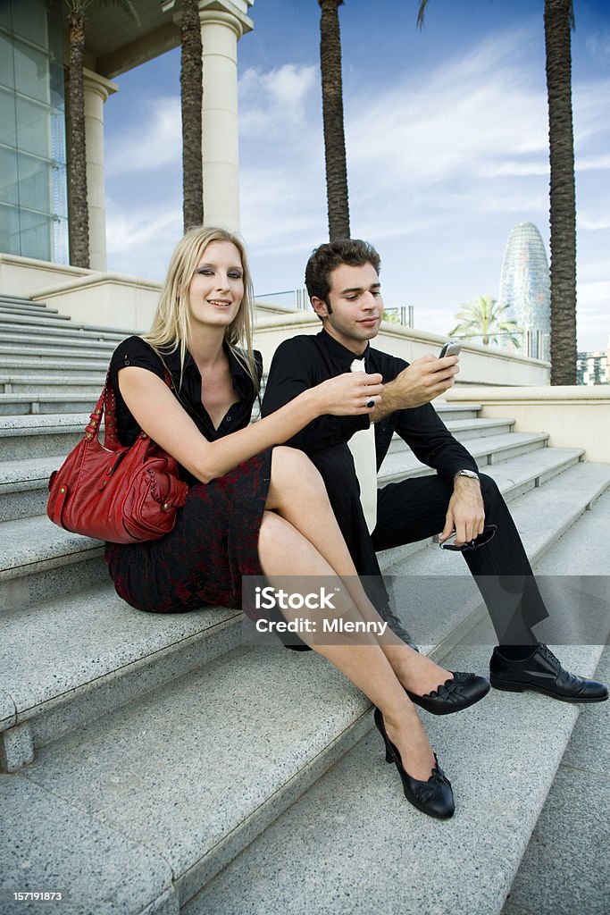 young couple sitting making call with cell phone friendly young couple sitting on stairs, waiting, man making a telephone call Businesswoman Stock Photo