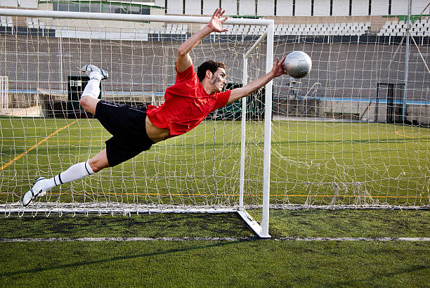 サッカー選手ボールを集めます。 - catching football human hand ball ストックフォトと画像