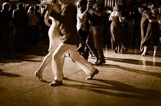Couple dancing Argentine Tango outdoors at night. Open air milonga at night. Natural light, high ISO. tango dance stock pictures, royalty-free photos & images