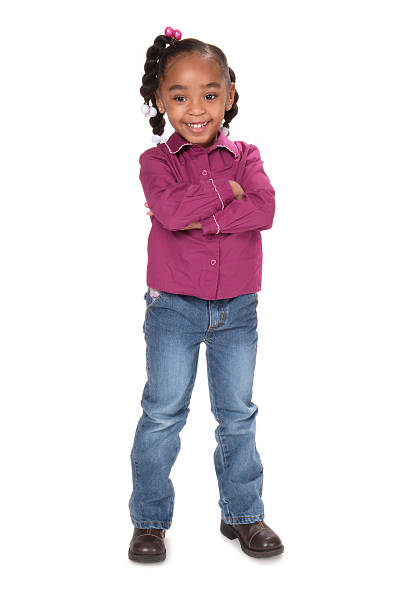 Serious African child seated at table with folded arms