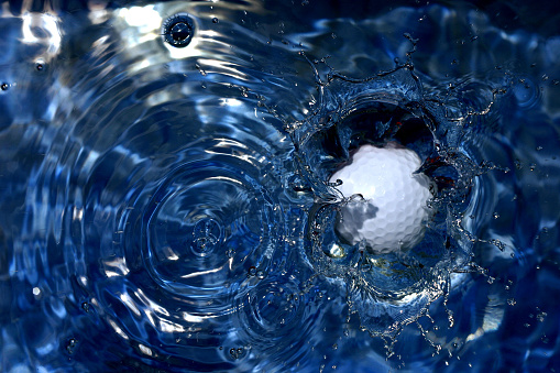 Photo of a golf ball landing in water hazzard.