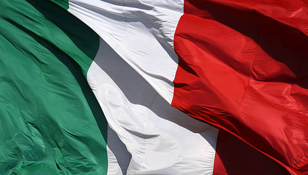 Flag of Italy with vertical strips of green, white and red Italian flag  in sun and wind italian flag stock pictures, royalty-free photos & images