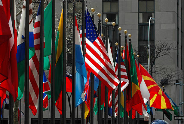 Line of flags from all different countries and nations The American flag stands out among others from around the world on display at Rockefeller Center in Manhattan diplomacy photos stock pictures, royalty-free photos & images